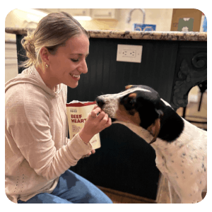 Woman feeding dog Beef Heart treats