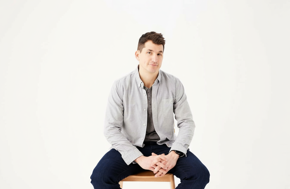 an image of a man sitting on a chair with his hands crossed