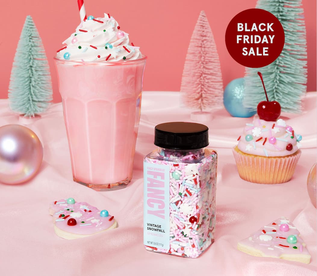 A jar of our Vintage Snowfall holiday sprinkle blend, next to decorated cupcake and milkshake. 