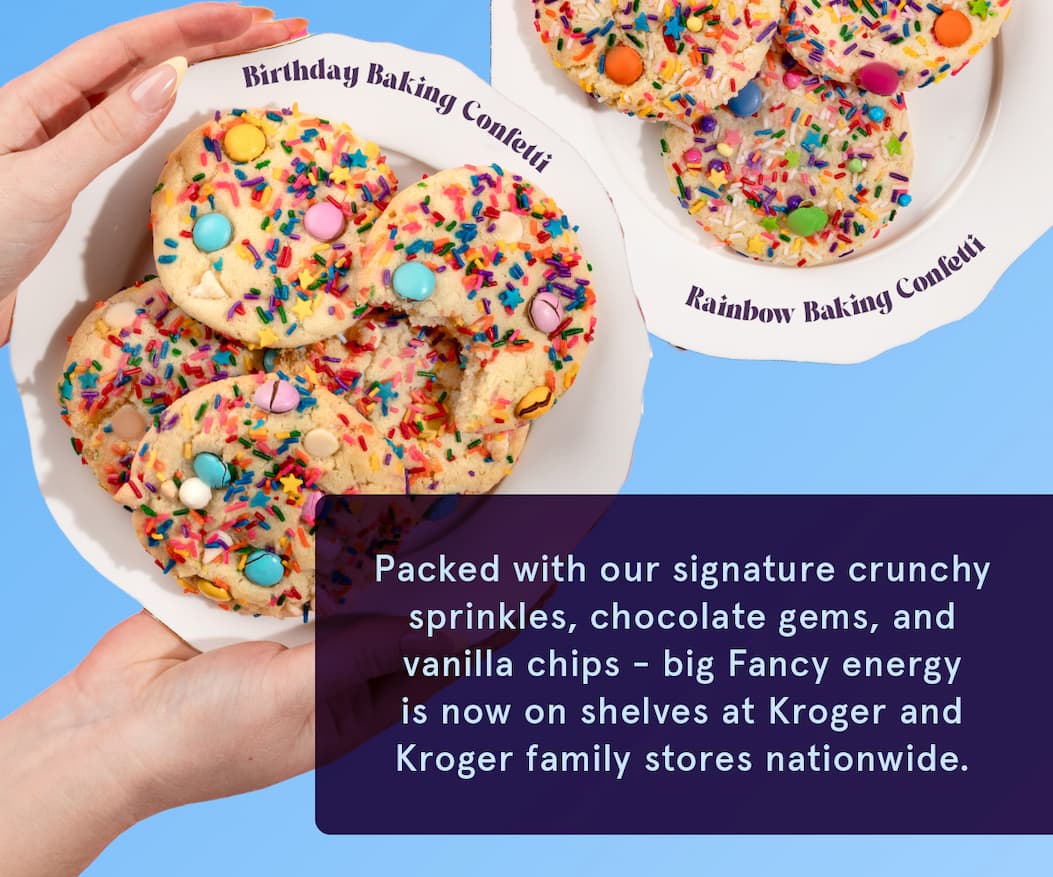 We see an image of two plates piled with colorful baking confetti cookies. Packed with our signature crunchy sprinkles, chocolate gems, and vanilla chips, big Fancy energy is now on shelves at Kroger and Kroger family stores nationwide.