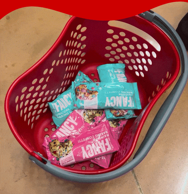 The gif shows a red target shopping basket filled with Fancy Unicorn and Rainbow baking confetti bags. Click to shop now!
