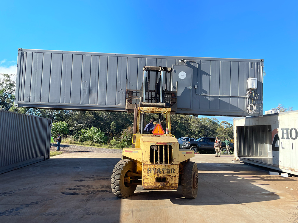 Shipping container being moved into place