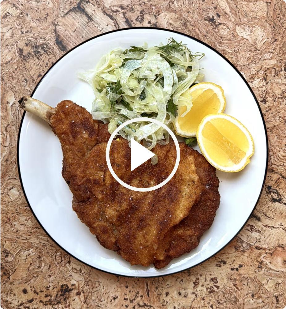 Pork schnitzel with fennel salad and lemon on a plate