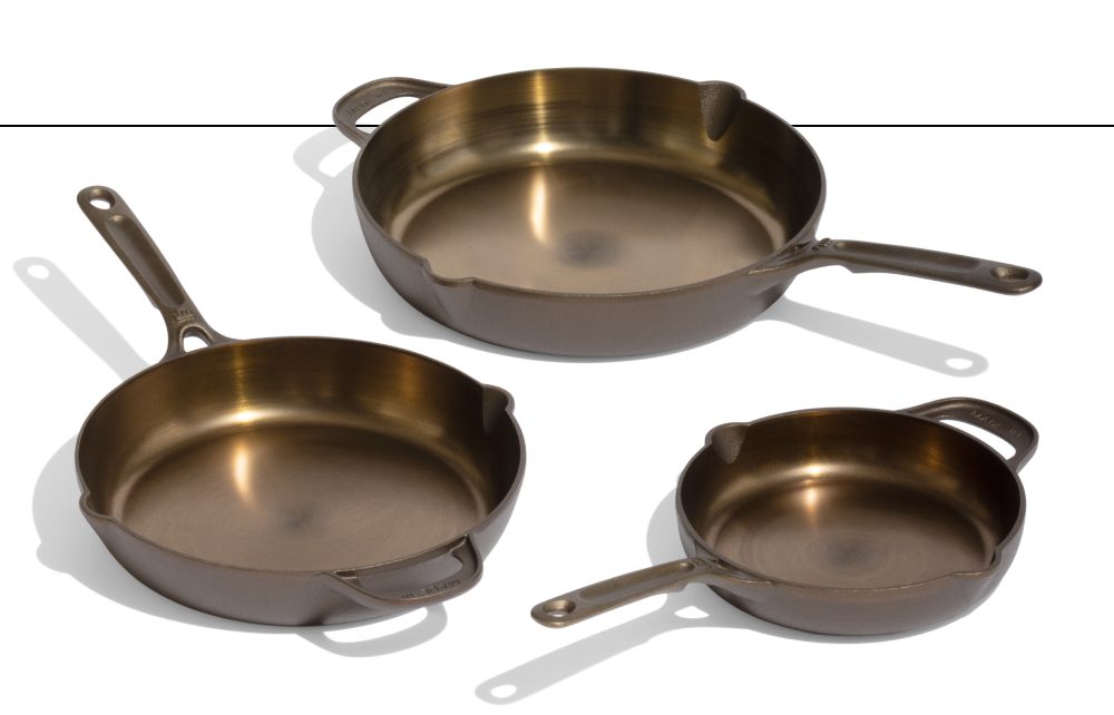 Three seasoned cast iron skillets in graduated sizes