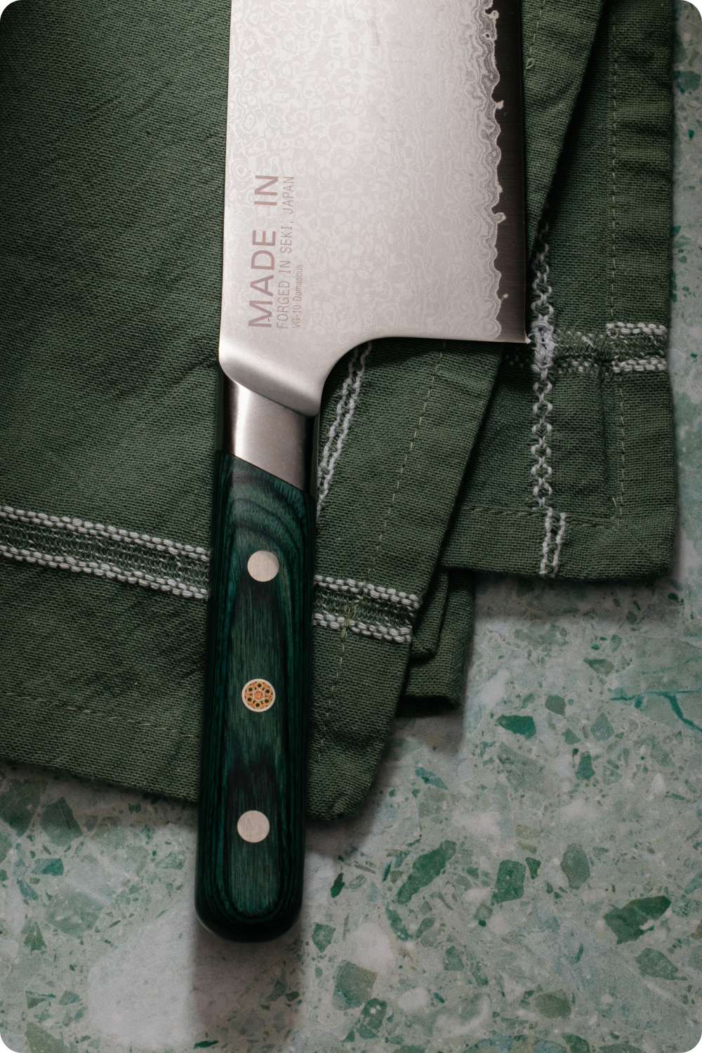 Kamagata knife on a green linen napkin over terrazzo
