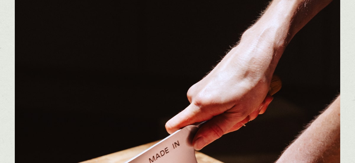 Hands breaking down chicken using the Made In Olive Wood Cleaver. Hands breaking down chicken using the Made In Olive Wood Cleaver.