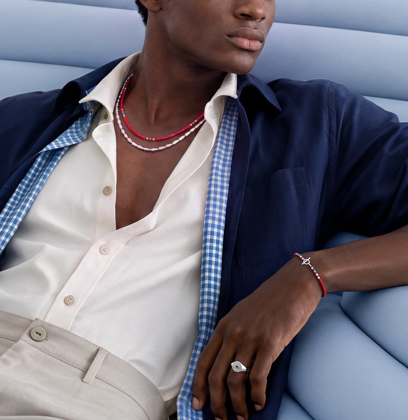 Man lounging with jewelry. 