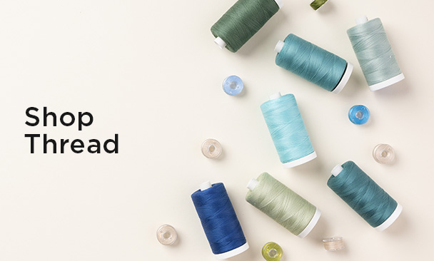 Text: Shop Thread Image: a colorful assortment of thread spools