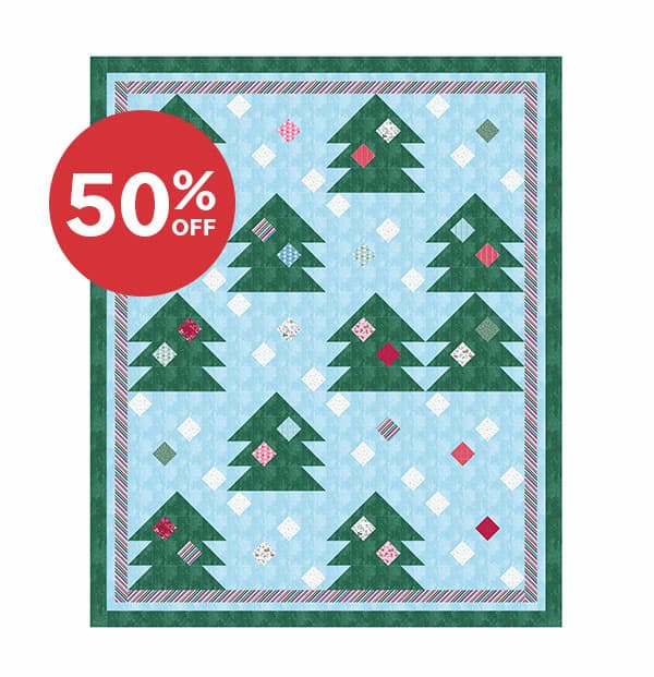 Image: A light blue quilt with green trees and holiday baubles. Text: 50% off >>