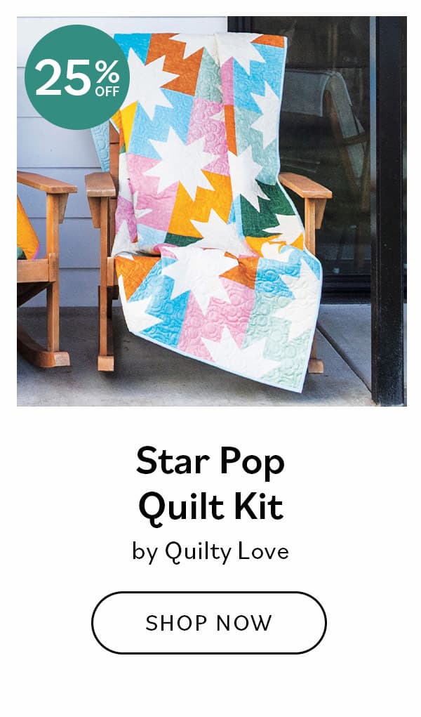 Image: A brightly colored quilt with white stars draped over an adirondak patio chair. Text: Star Pop Quilt Kit by Quilty Love. Shop Now >>
