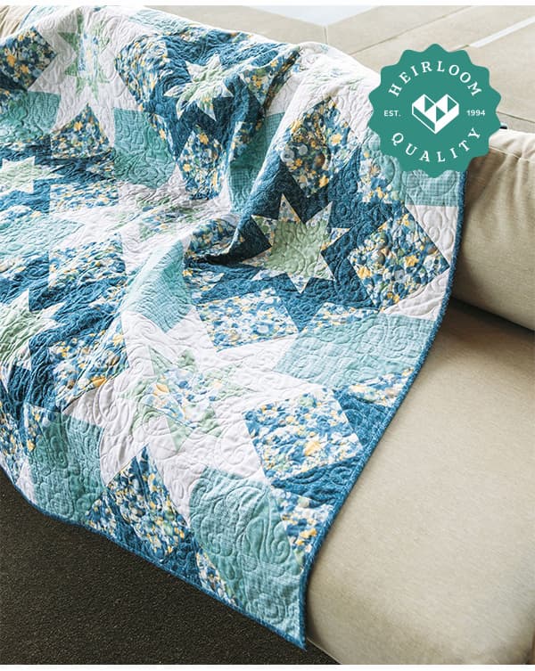 A blue white and green handmade quilt laying on a couch