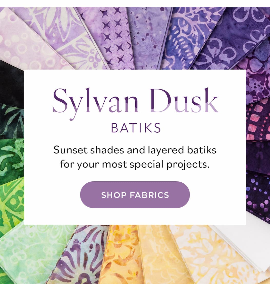 Image: Purple, green, and golden batik fabrics. Text: Sylvan Dusk Batiks. Sunset shades and layered batiks for your most special projects. Shop Fabrics >>