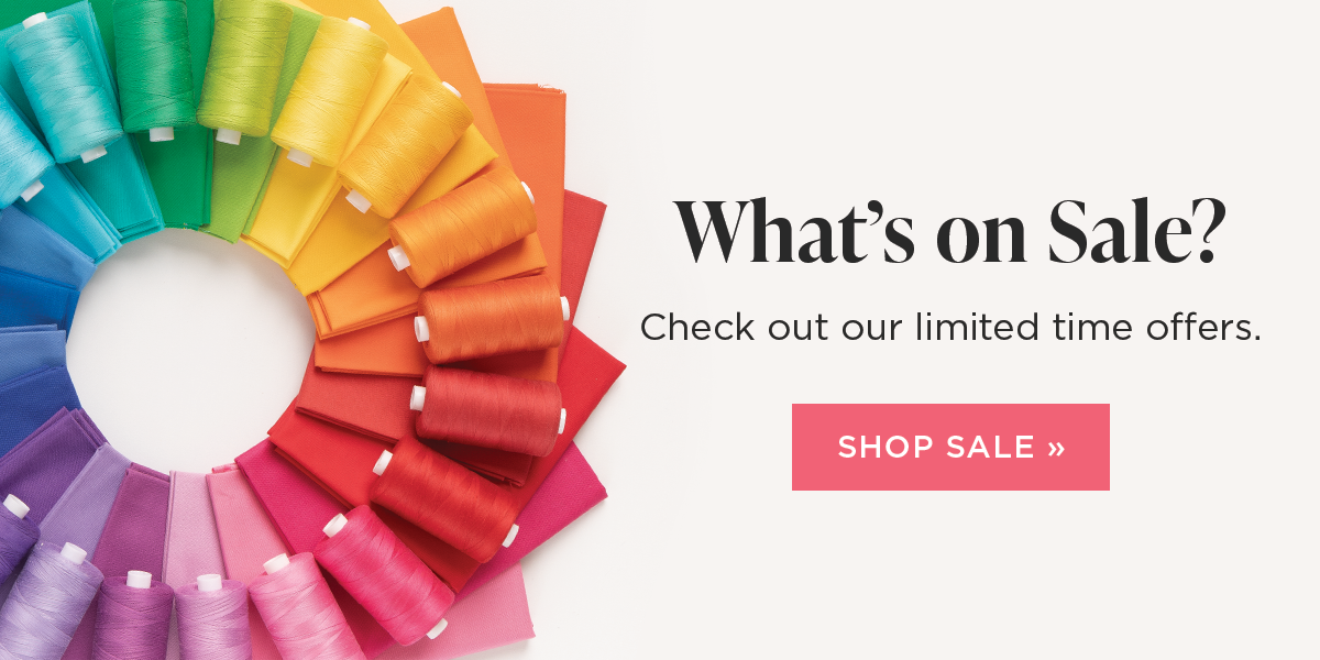 Image: Spools of brightly colored thread arranged in a rainbow gradient atop matching fabrics. Text: What's on Sale? Check out our limited time offers. Shop sale >>
