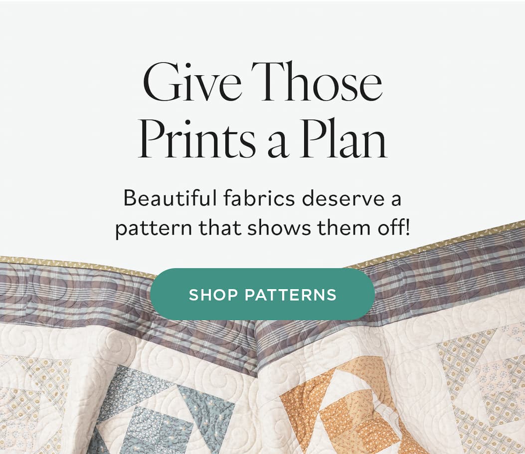 Image: A quilt with cream background and neutral toned blocks. Text: Give Those Prints a Plan. Beautiful fabrics deserve a pattern that shows them off! Shop Patterns >>