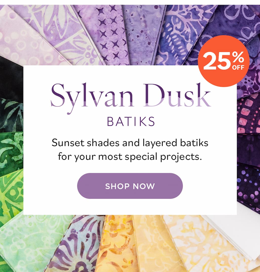 Image: Batik quilting fabrics in shades of purple, soft golden yellow, and vibrant greens. Text: Sylvan Dusk Batiks. Sunset shades and layered batiks for your most special projects. 25% off. Shop Now >>