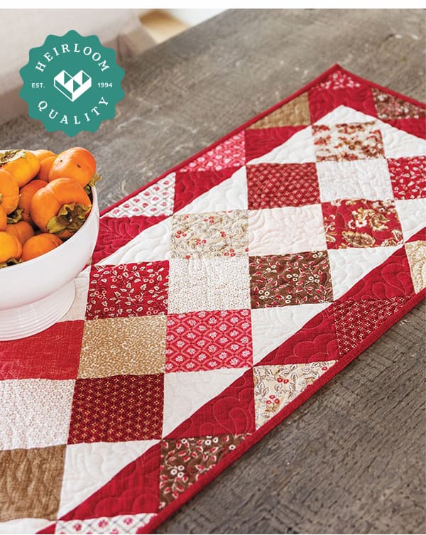 A red and white quilt runner on top of a table
