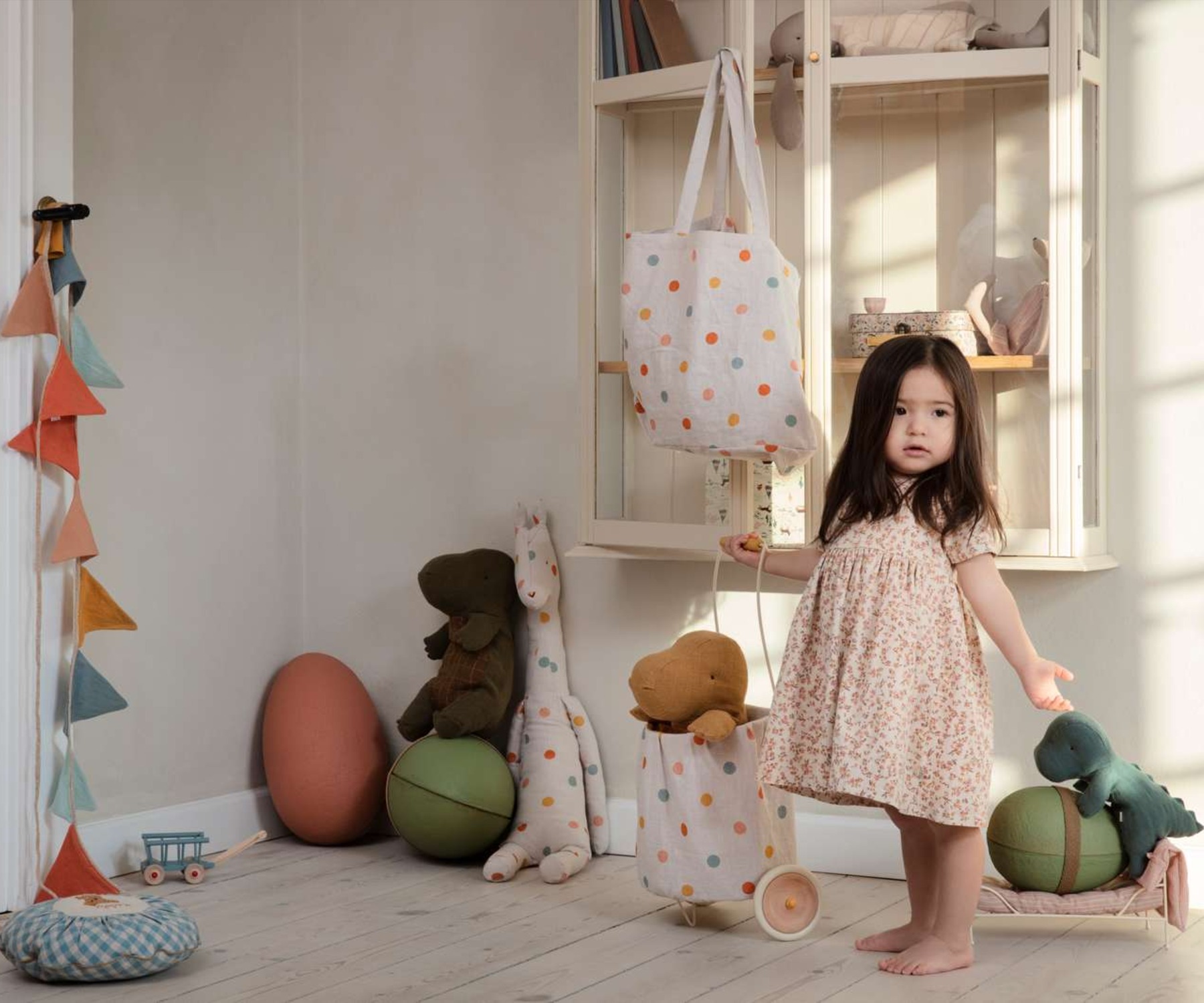 Maileg Dinosaurs and little girl playing in playroom.