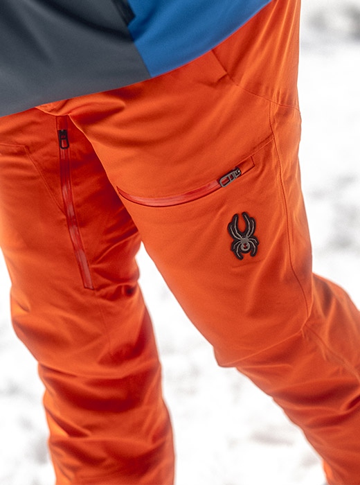 Waist down photo of skier wearing orange ski Dare Pants