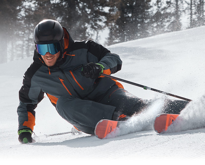 River Radamus, skiing close up to the camera wearing the Vyper Jacket in Slate Blue