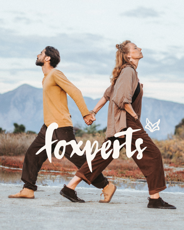 The picture shows two people holding hands, standing with their backs to each other and looking in opposite directions. Both people are wearing the model Faunus. The word ‘Foxperts’ can also be seen.