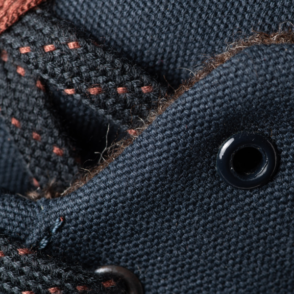 The image is very close-up photo of Tejo blueberry. They eyelets, laces and canvas fabric are visible in detail, showing the fabric weave, the inner lining and the rust colored feature in the laces. 