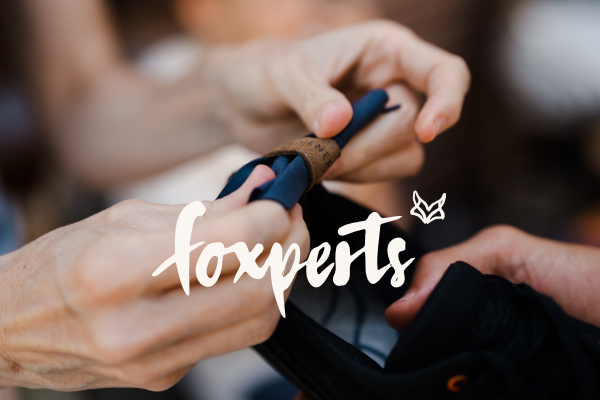 The photo shows a Wildling employee in the Wildling atelier. He is sitting at a table on which various Wildling models are displayed, and is talking to someone who is not visible