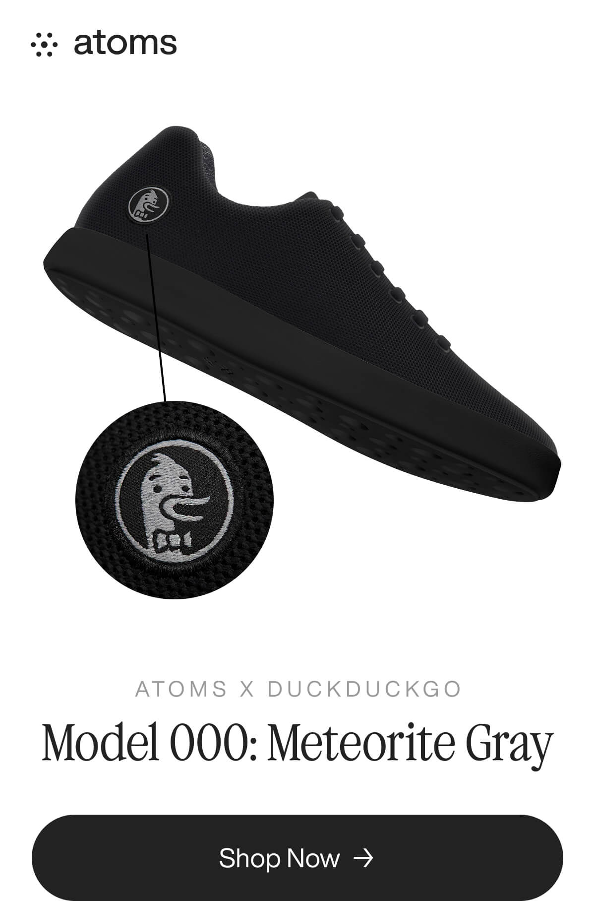 Black sneaker with a grayscale DuckDuckGo logo, labeled "Model 000: Meteorite Gray." The tone is sleek and modern. Brand: Atoms. Shop button below.