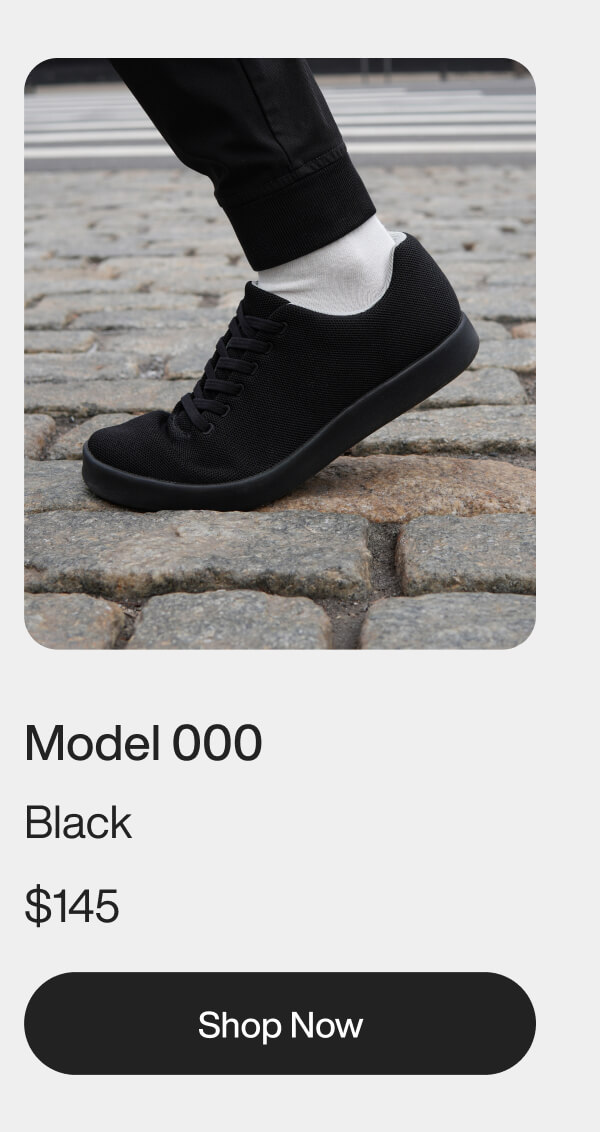 A black sneaker with a sleek design is worn by a person in white pants. The text reads "Model 000 Meteorite." There is a "Shop Now" button below.