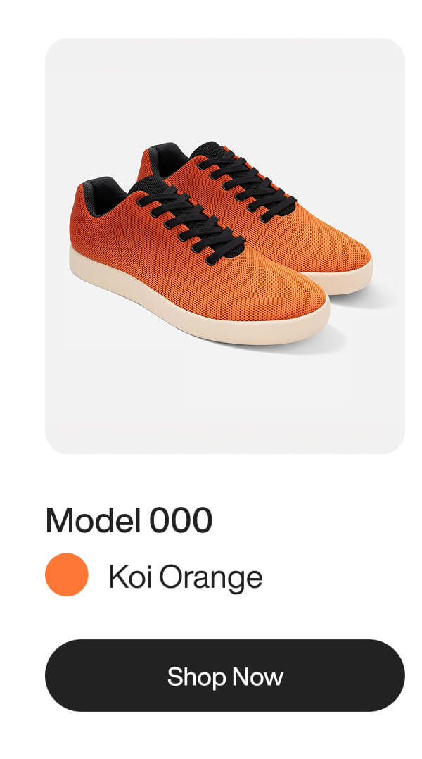 Koi orange sneakers with black laces and a light beige sole on a white background.