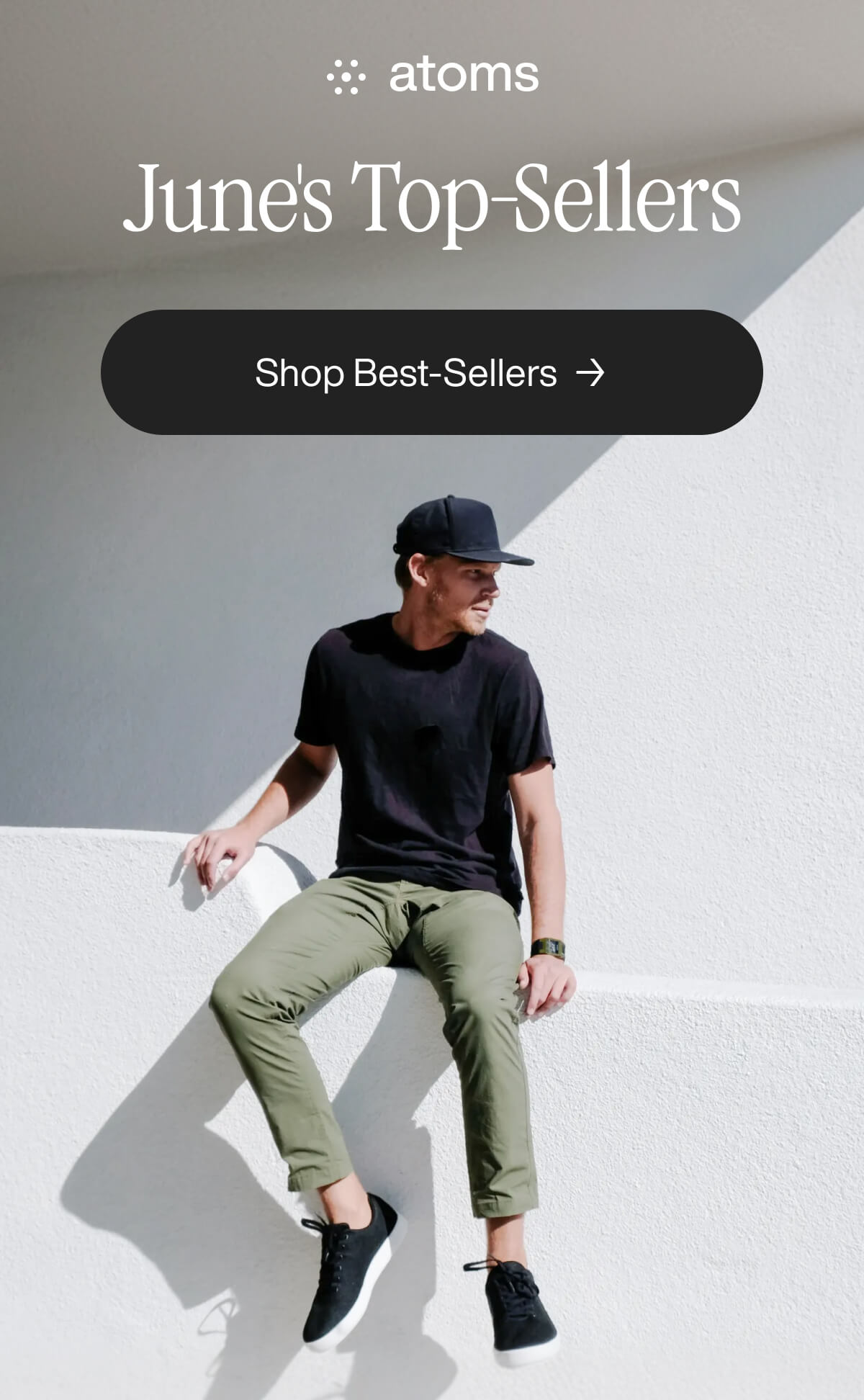 Man in casual attire sits on a white wall. Text reads "June's Top-Sellers" with a button labeled "Shop Best-Sellers.