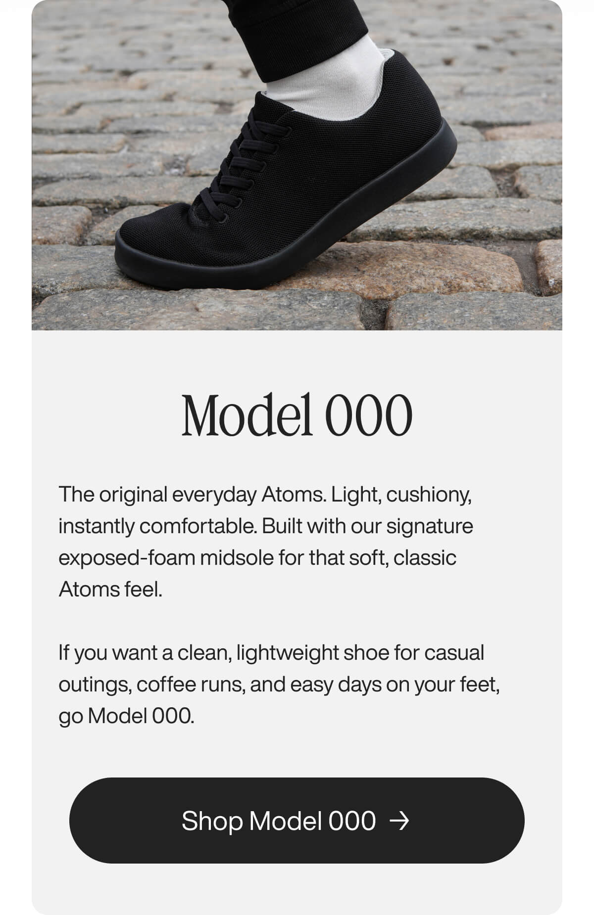 Close-up of a black sneaker on cobblestone, highlighting comfort and style. Text reads: "Model 000 – everyday light, cushiony shoe." Button says "Shop Model 000."