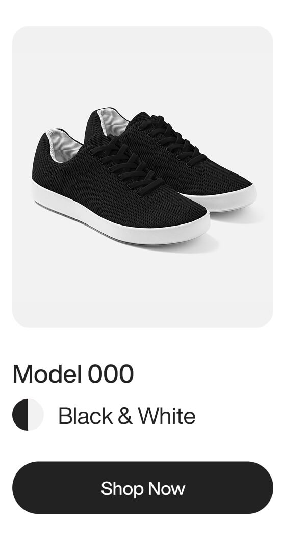 A pair of black knit sneakers with white soles and matching black laces.