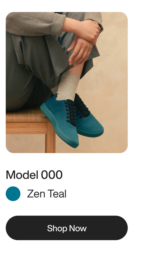Person seated on a wooden stool wearing teal sneakers with black laces, gray pants, and light socks. Text below reads "Model 000, Zen Teal, Shop Now."