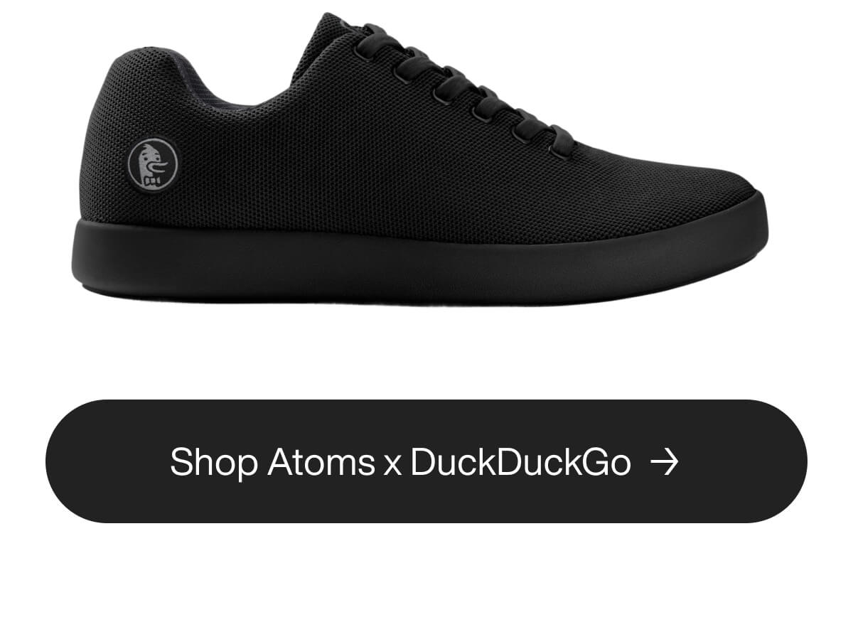Black sneaker with a sleek design and round logo on the heel. Below, a button reads "Shop Atoms x DuckDuckGo" on a dark background.