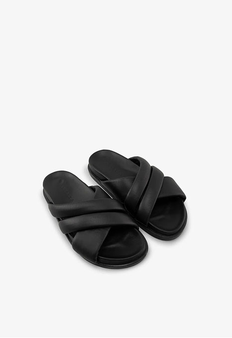 The Bay Sandals feature wide overlapping padded straps and flat soles.