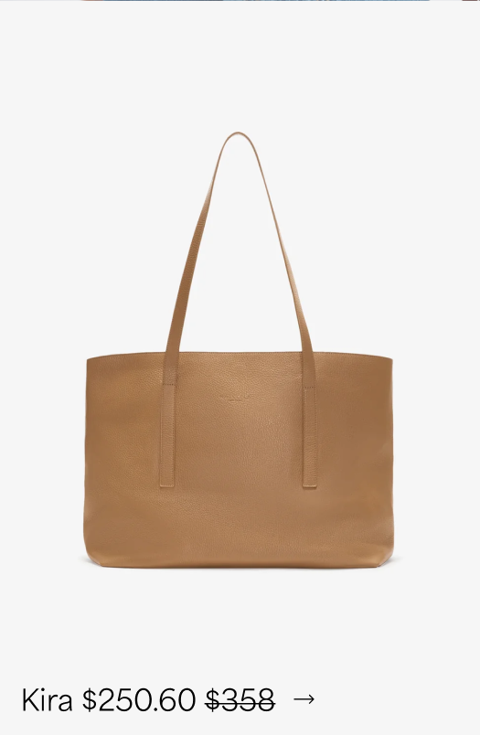 A cafe pebble Kira Tote with a spacious rectangular silhouette and two long slim handles is displayed against a white background.
