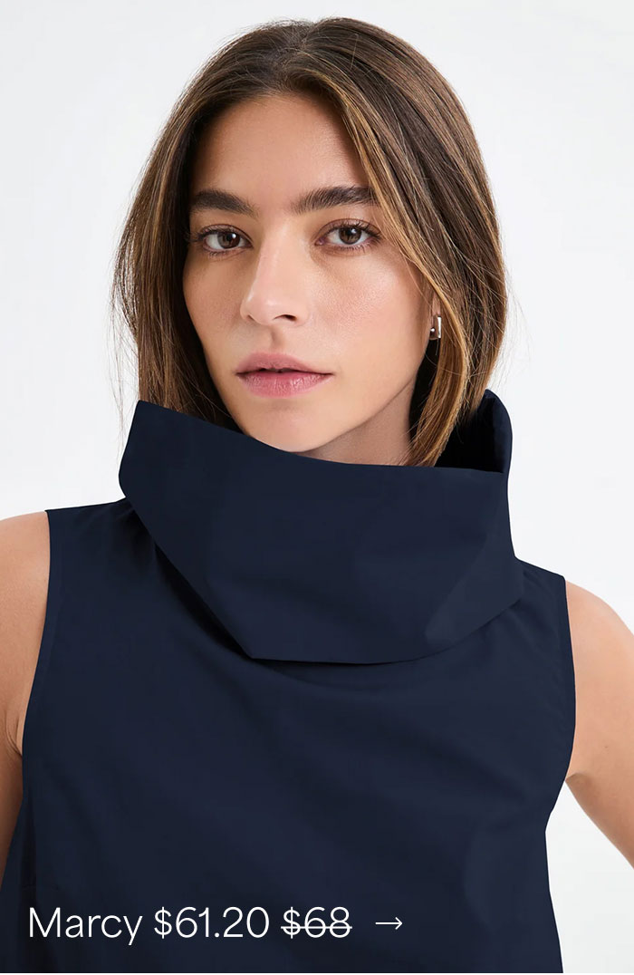 Rocio wears a deep indigo Marcy Sleeveless Top with an oversized sculptural high collar, priced at $61.20, originally $68.