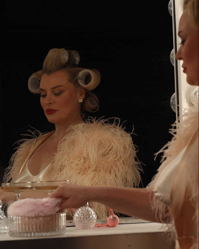 GIF of a woman with hair in rollers in a vintage bra and feather robe powdering her face. Face is caked in powder and frame fades to "Not your mother's powder. Launching Friday. Get early access"