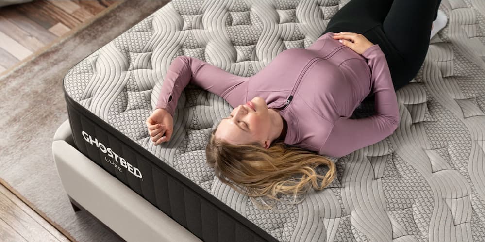 A woman resting peacefully on a GhostBed Luxe mattress