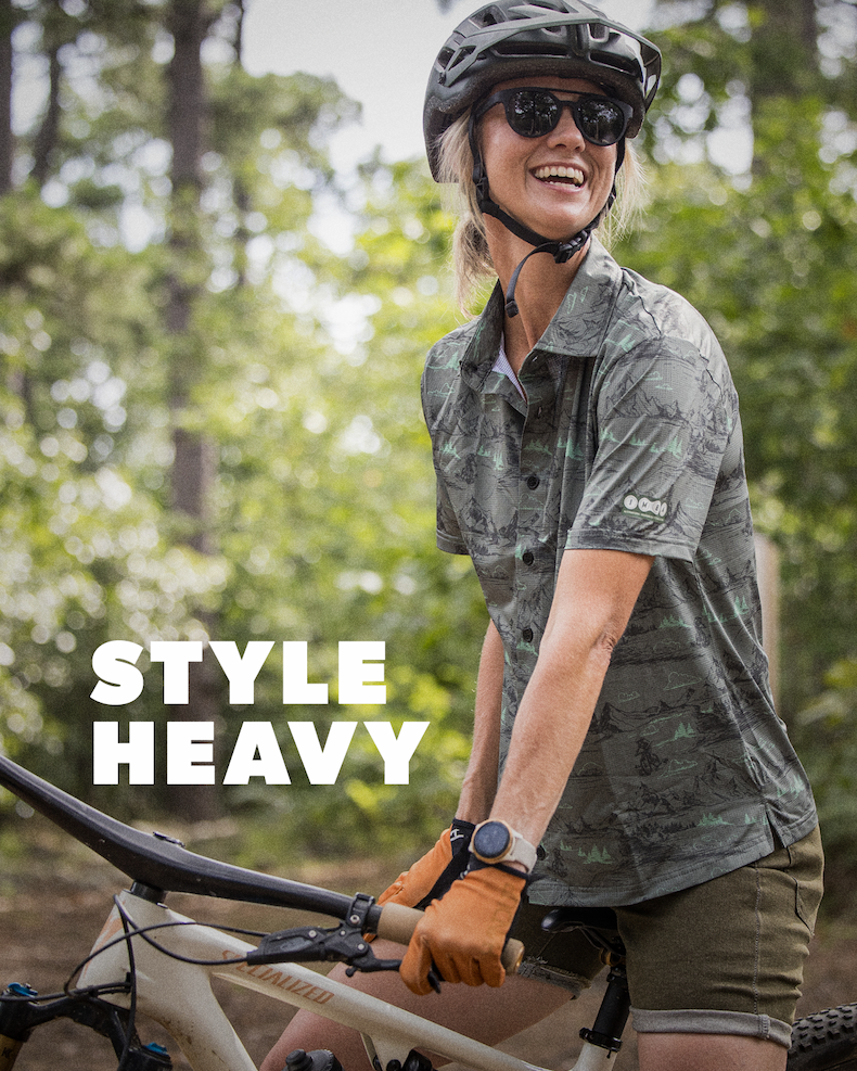 Image showing a woman with a mountain bike featuring the text "Style Heavy"