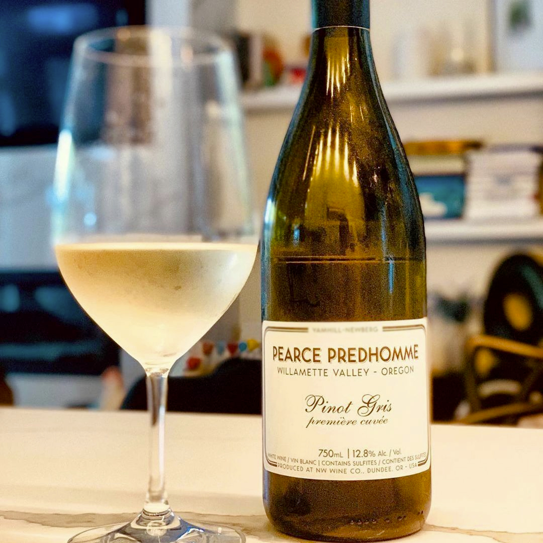Glass and bottle of Pinot Gris Willamette Valley 2021 by Pearce Predhomme set on white table.