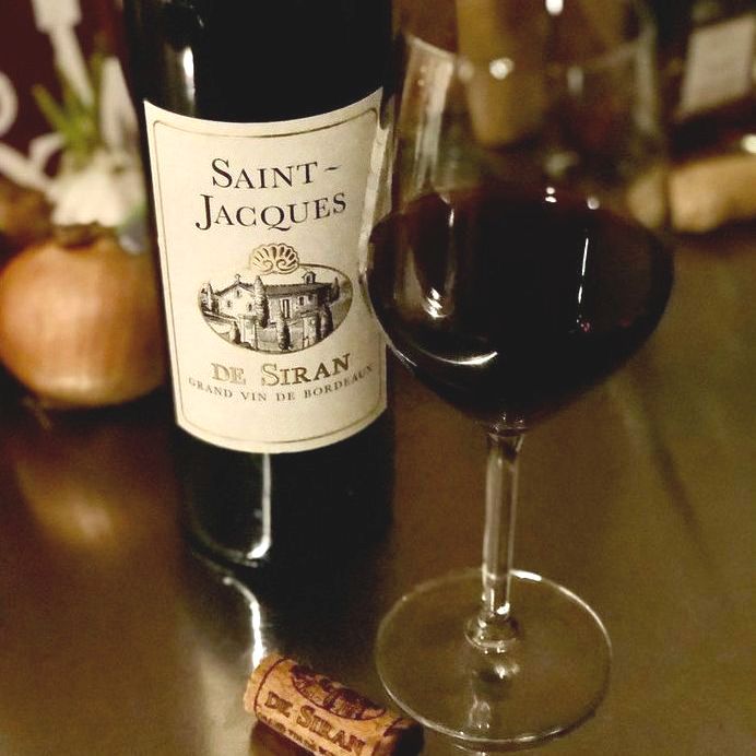 Bottle and glass of Saint-Jacques De Siran Bordeaux Superieur by Château Siran 2017 on a table.