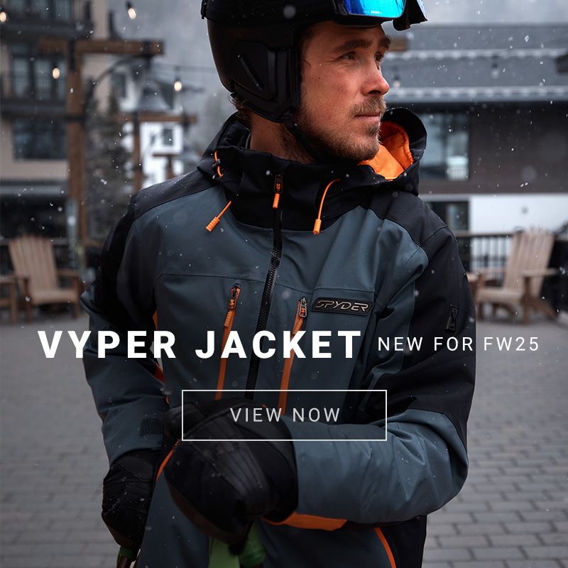 Male skier in slate blue and orange ski jacket at a resort