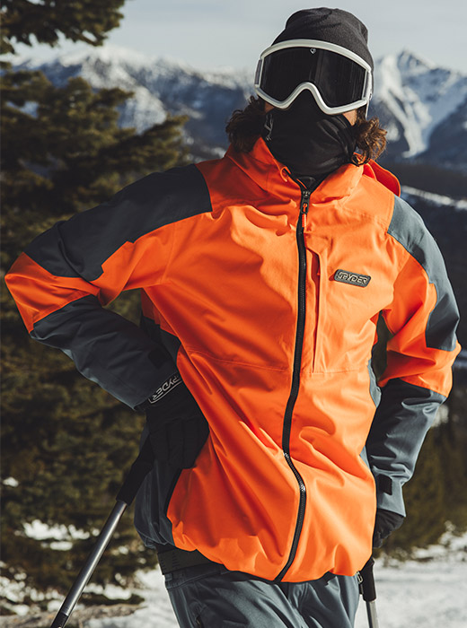 Skier in orange and grey Spyder Jacket.