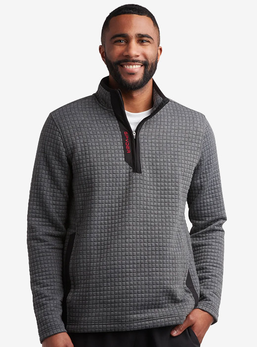 Man wearing a grey quilted sweater with a red Spyder logo