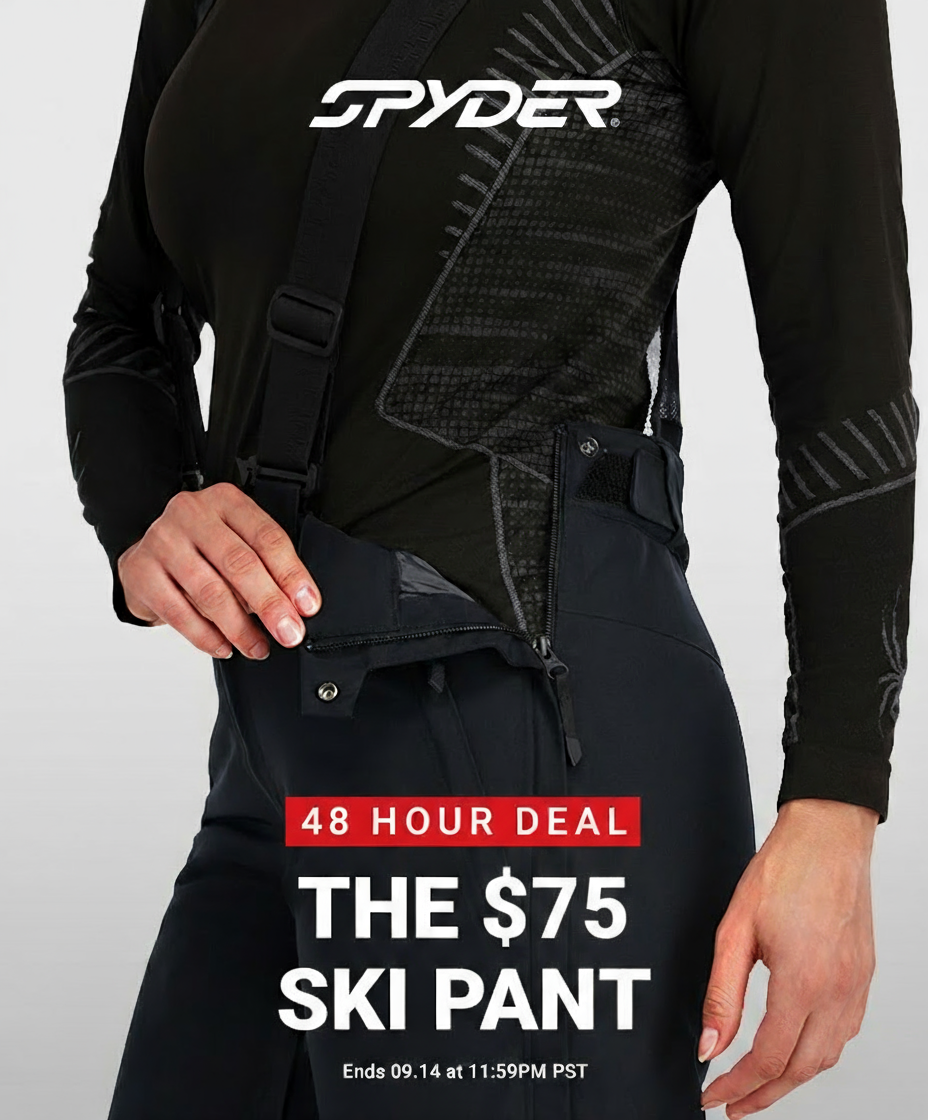 Woman wearing a Spyder ski pant showing the full leg zip feature on a light grey background