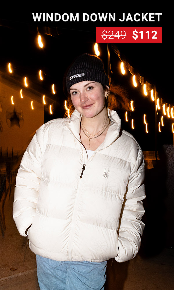 Girl walking at night wearing a puffy white jacket under strings of lights. Windom Down Jacket was $249, now $112