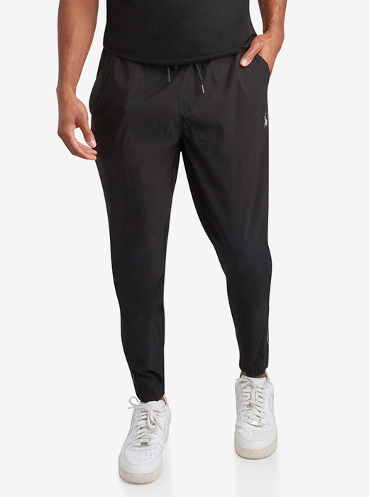 Male model waist down photo of Spyder Track Pants with a light grey studio background
