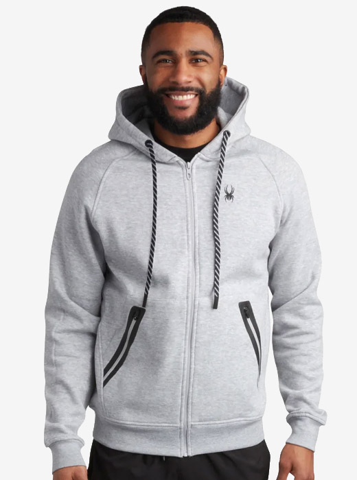 Man wearing a grey quilted sweater with a red Spyder logo