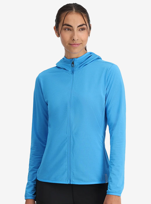 Woman wearing a blue performance fleece on grey studio background